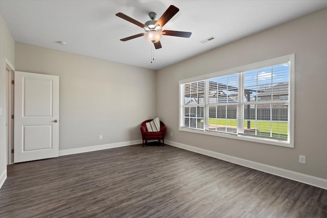 spare room featuring ceiling fan, a healthy amount of sunlight, and dark hardwood / wood-style flooring