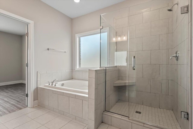 bathroom with separate shower and tub and tile patterned flooring