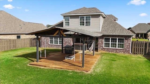 back of property featuring a gazebo, a hot tub, a deck, and a lawn