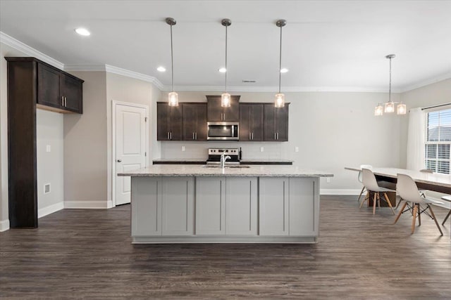 kitchen featuring light stone countertops, a kitchen island with sink, pendant lighting, and stainless steel appliances