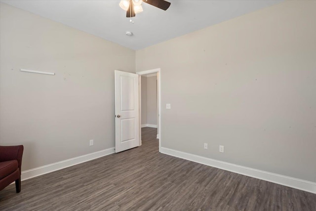 unfurnished room with ceiling fan and dark wood-type flooring