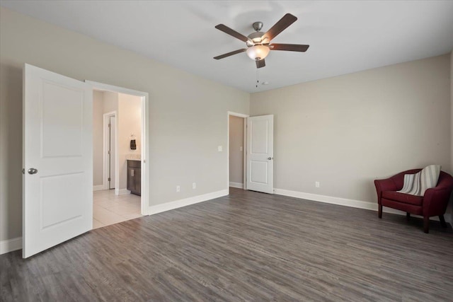 interior space featuring ensuite bathroom, ceiling fan, and dark wood-type flooring