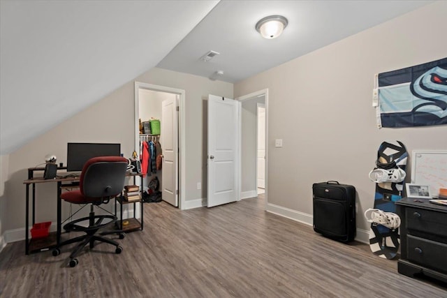 home office with wood-type flooring and vaulted ceiling