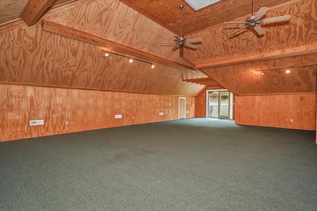 additional living space featuring vaulted ceiling with beams, wooden walls, ceiling fan, and carpet