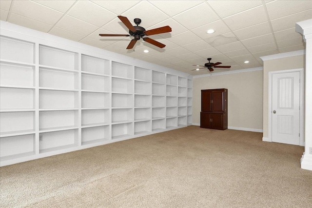 spare room with built in features, carpet floors, ornamental molding, and ceiling fan