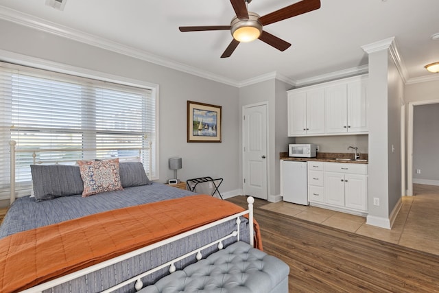 bedroom with ceiling fan, light wood-type flooring, ornamental molding, and sink