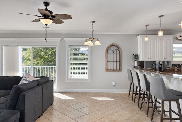 interior space featuring open floor plan, white cabinetry, a breakfast bar area, and a healthy amount of sunlight