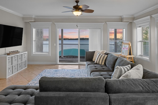 living room featuring baseboards, ornamental molding, light tile patterned floors, a ceiling fan, and a water view