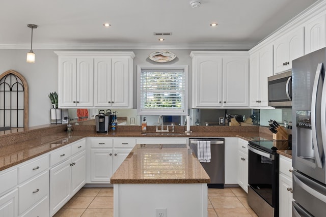 kitchen featuring dark stone counters, a sink, ornamental molding, and stainless steel appliances