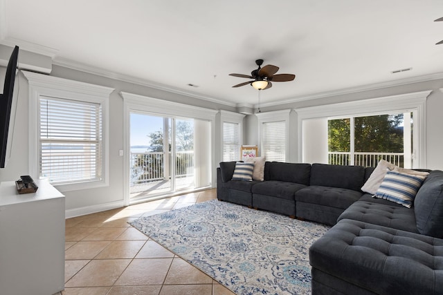 living area featuring visible vents, baseboards, ceiling fan, crown molding, and light tile patterned flooring