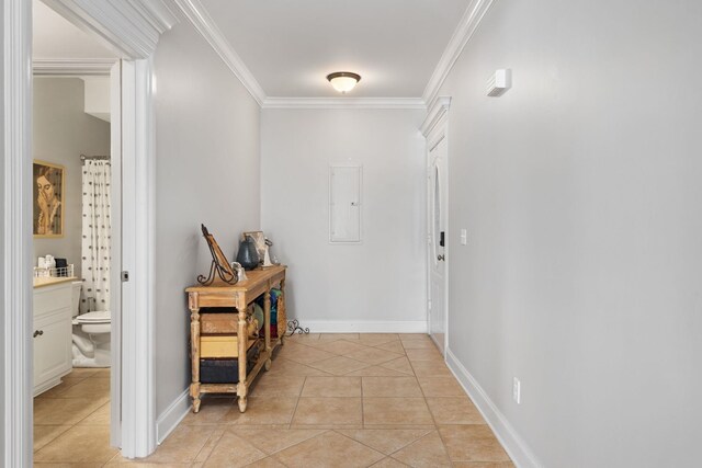 hallway featuring crown molding, baseboards, light tile patterned flooring, and electric panel
