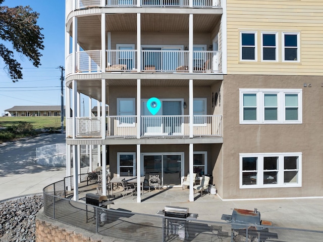 rear view of house featuring a patio area and stucco siding