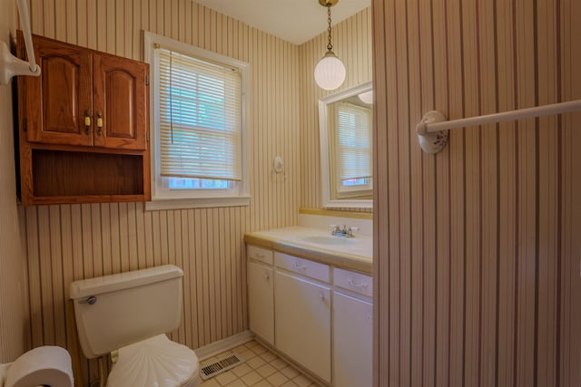  - bathroom with wallpapered walls, toilet, vanity, and baseboards