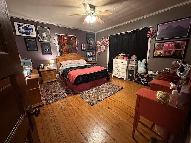 bedroom with ornamental molding, a ceiling fan, and wood finished floors