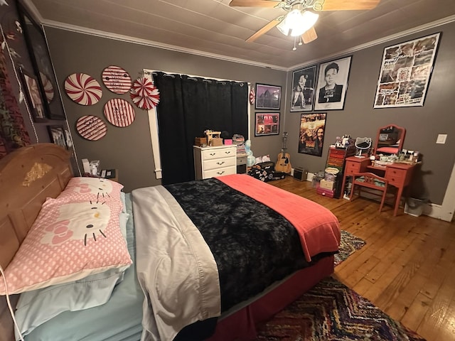 bedroom featuring ornamental molding, wood finished floors, and a ceiling fan