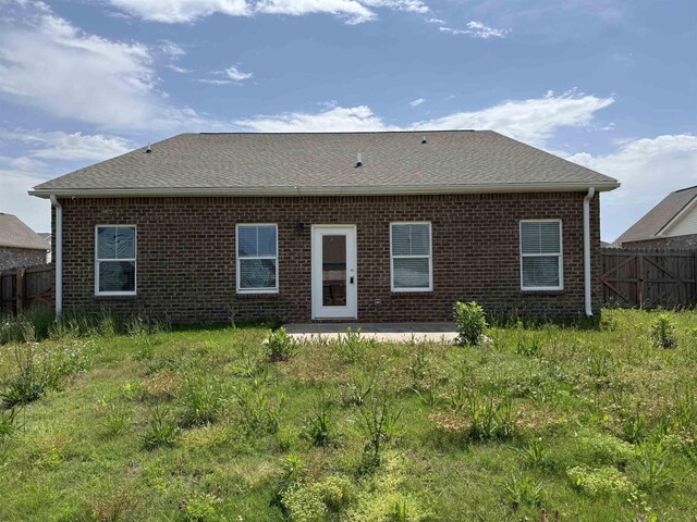  - back of house with fence, brick siding, a patio, and roof with shingles