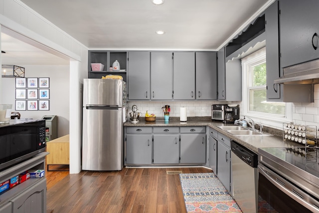  - kitchen featuring stainless steel appliances, gray cabinetry, dark countertops, tasteful backsplash, and recessed lighting