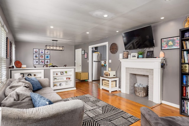  - living area featuring wood finished floors, recessed lighting, and a fireplace