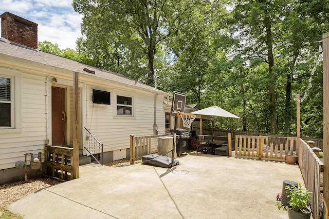  - view of patio / terrace with entry steps, a grill, and view of wooded area