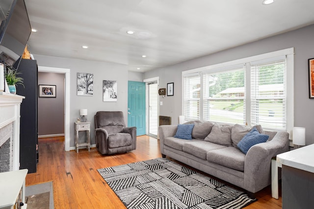  - living room featuring light wood-type flooring, recessed lighting, and a high end fireplace