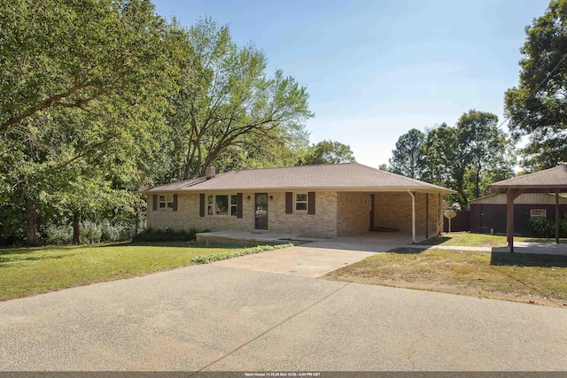 ranch-style home featuring a carport and a front yard