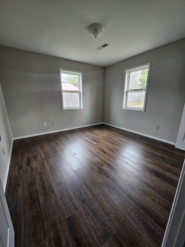 spare room featuring dark hardwood / wood-style floors and plenty of natural light