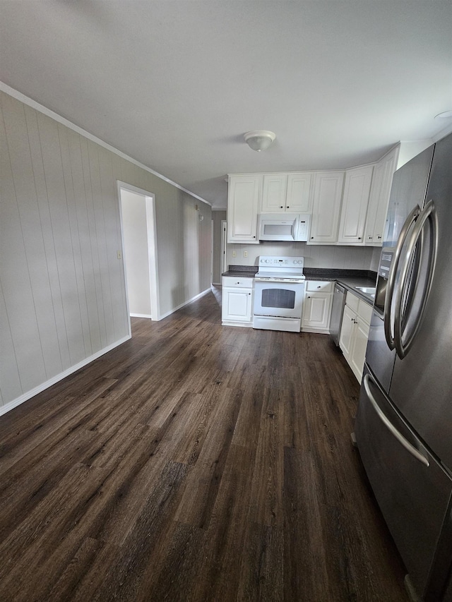 kitchen with ornamental molding, stainless steel appliances, white cabinetry, and dark hardwood / wood-style floors