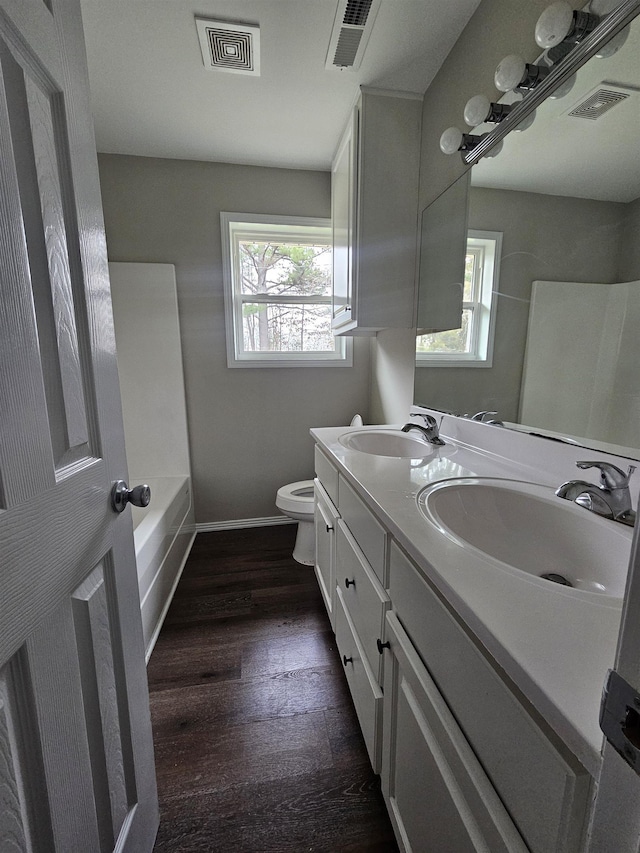 bathroom with vanity, toilet, and hardwood / wood-style floors