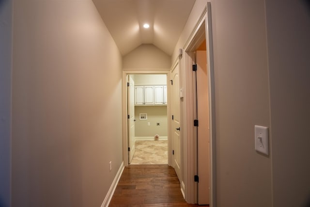 hallway featuring wood-type flooring and lofted ceiling