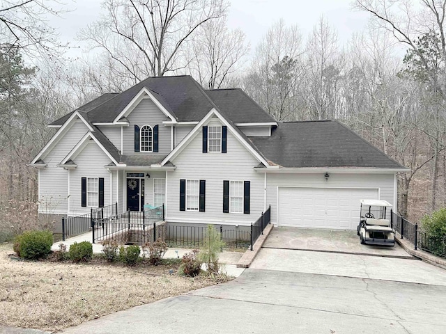 traditional-style house with a garage, roof with shingles, driveway, and fence