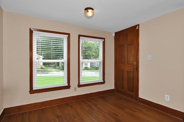 - spare room with baseboards and dark wood-type flooring