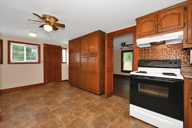  - kitchen featuring range with electric cooktop, under cabinet range hood, ceiling fan, and brown cabinets