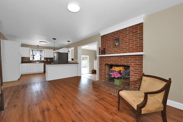  - living area with dark wood-type flooring and a brick fireplace