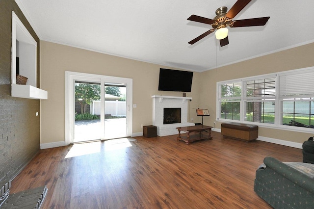  - living area with crown molding, wood finished floors, healthy amount of natural light, and a fireplace