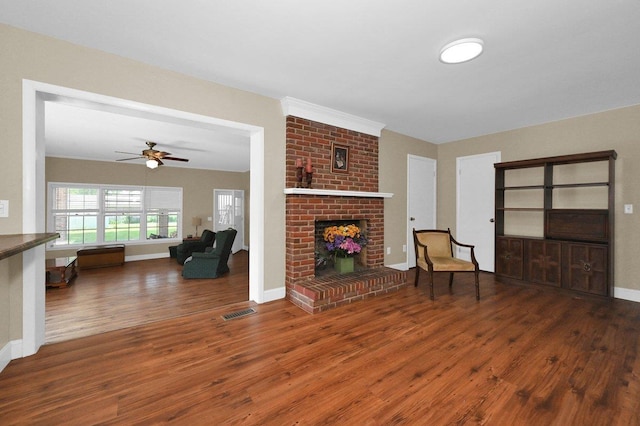  - living area featuring wood finished floors, a ceiling fan, and a brick fireplace