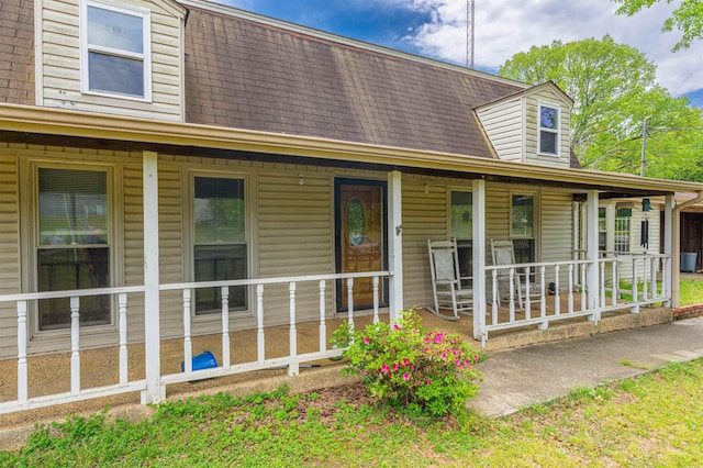 view of front of property with a shingled roof and covered porch