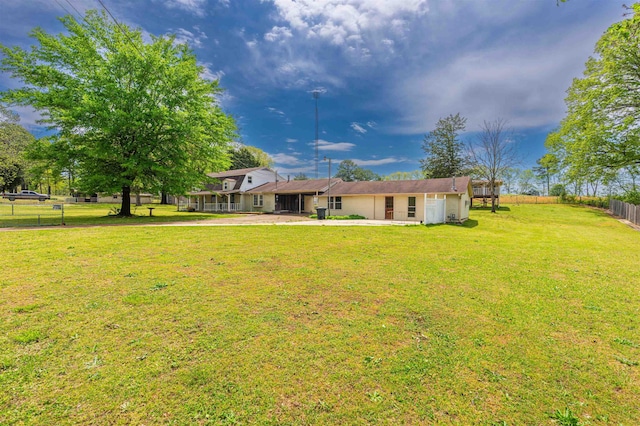 back of house with fence and a yard