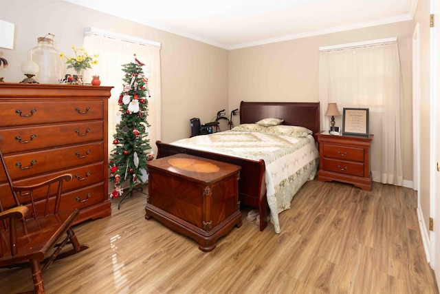 bedroom with light wood-type flooring and crown molding