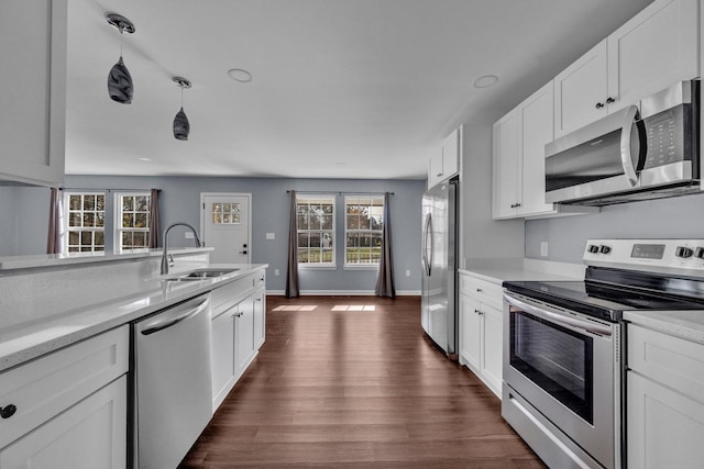 kitchen featuring sink, decorative light fixtures, dark hardwood / wood-style flooring, white cabinetry, and stainless steel appliances