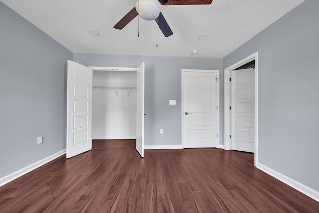 unfurnished bedroom featuring ceiling fan, a closet, and dark wood-type flooring