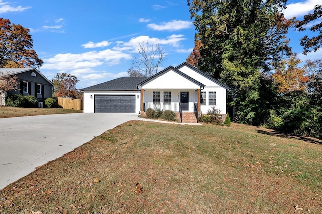 view of front of property with a porch, a garage, and a front lawn