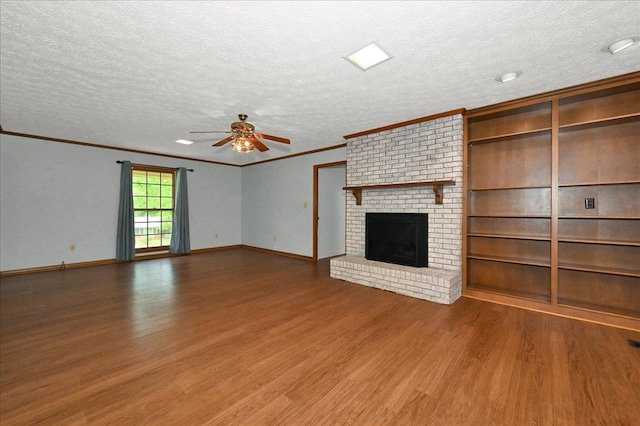 - unfurnished living room featuring wood finished floors, a ceiling fan, crown molding, a textured ceiling, and a brick fireplace