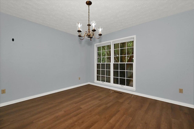  - unfurnished room featuring a chandelier, wood finished floors, baseboards, and a textured ceiling
