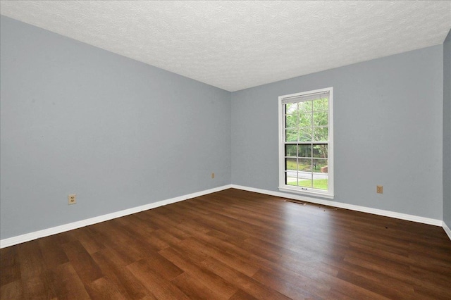  - spare room featuring wood finished floors, baseboards, and a textured ceiling