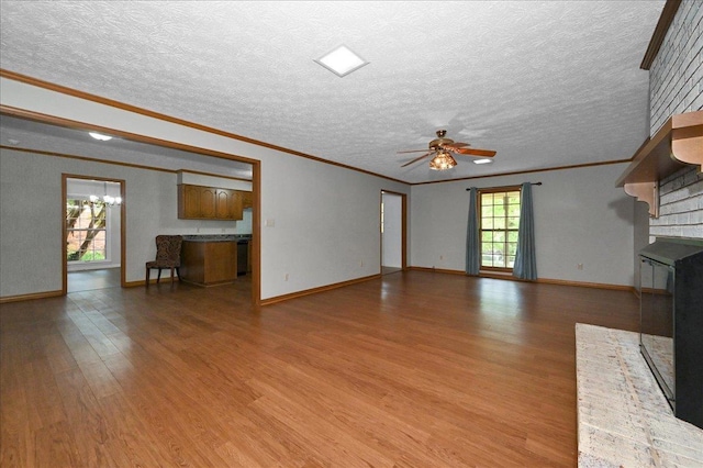  - unfurnished living room featuring light wood-style floors, ceiling fan, baseboards, crown molding, and a textured ceiling