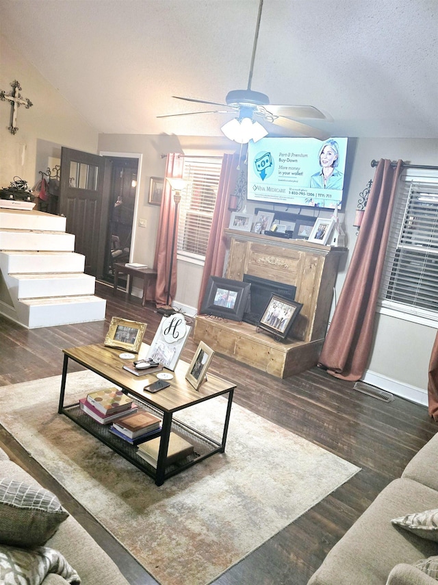 living room featuring ceiling fan, lofted ceiling, a textured ceiling, and dark hardwood / wood-style flooring