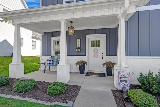 view of exterior entry featuring covered porch