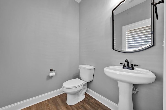 bathroom with hardwood / wood-style floors and toilet