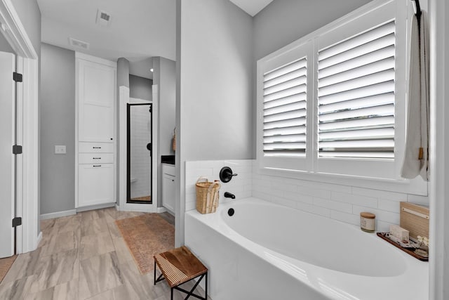 bathroom with separate shower and tub and a wealth of natural light