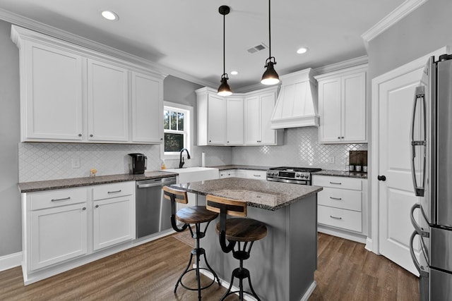 kitchen with white cabinets, custom range hood, a center island, and stainless steel appliances